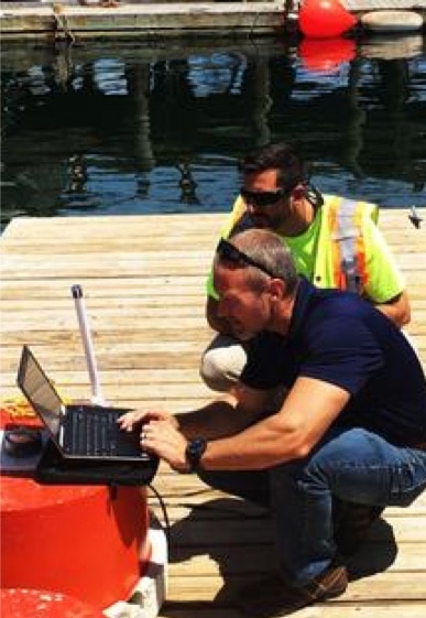 two men on a dock looking at a computer for the Z-Boat 1