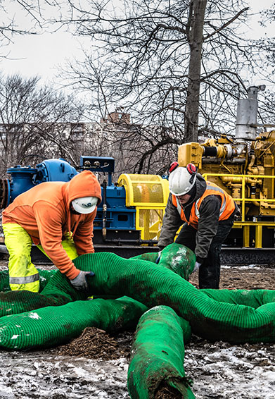 photo of 2 workers with equipment in the background