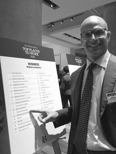 Bob pointing at charter on the list of globe's top places to work