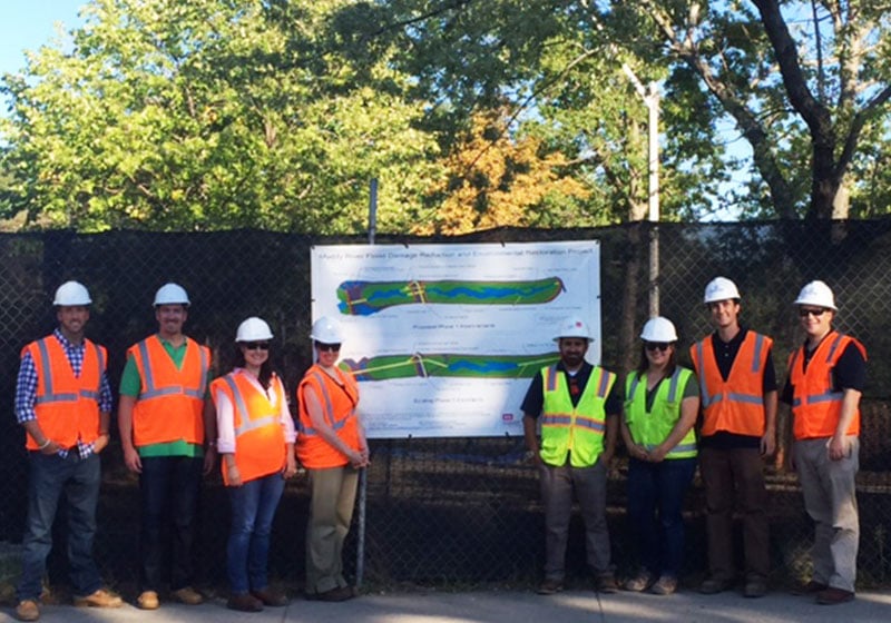 employees posing by a diagram of the muddy river